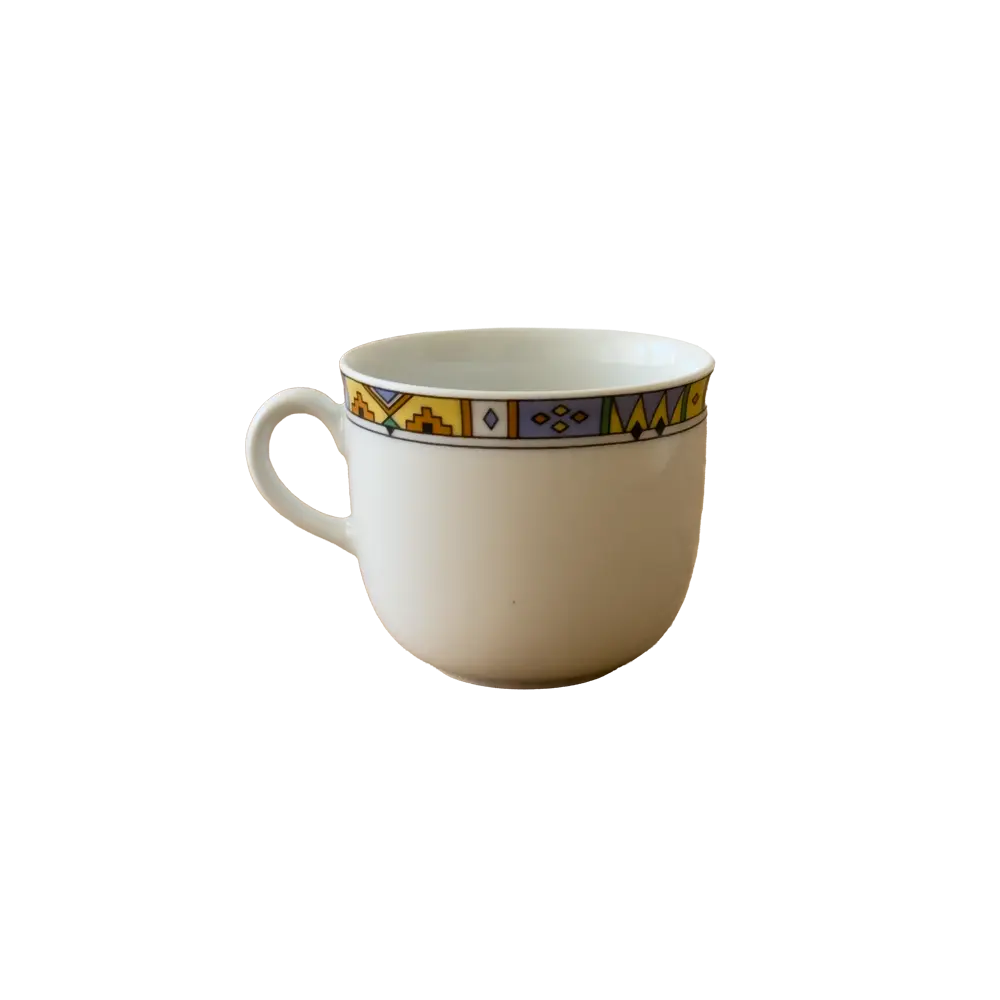 Freigestellte Fotografie einer kleinen Kaffeetasse mit buntem Muster am oberen Rand.
